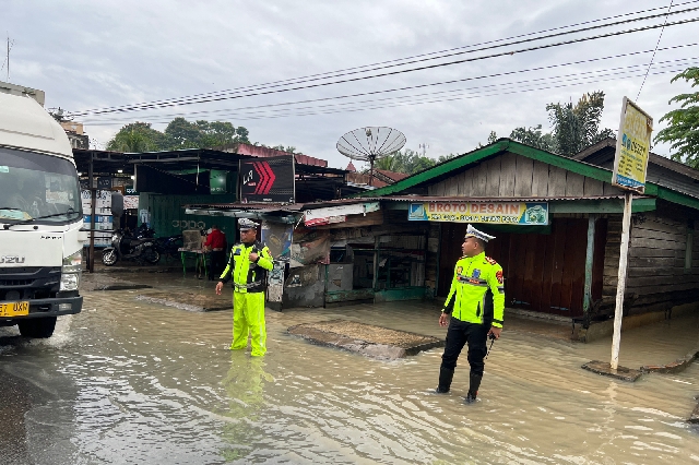 Kasat Lantas Polres Labuhan Batu, AKP Muhammad Ainul Yaqin SH SIK MH bersama dengan personil Sat Lantas Polres Labuhan Batu saat mengatur arus lalu lintas ditengah-tengah banjir di Aek Nabara, Kabupaten Labuhan Batu, Sumatera Utara. (Jhonson Siahaan)