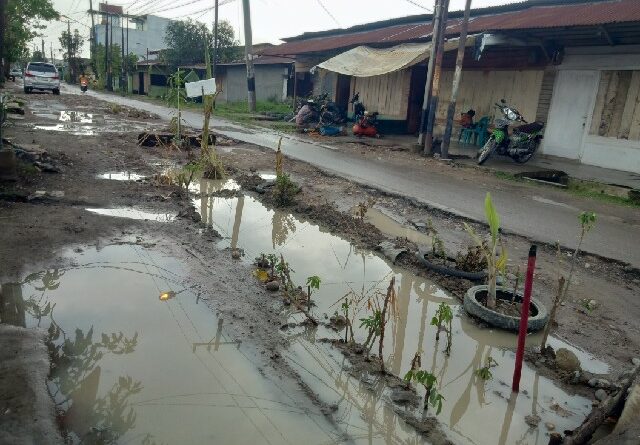 Jalan Menteng II, Kelurahan Binjai, Kecamatan Medan Denai, yang berlumpur dan berlubang mirip dengan kubangan kerbau saat hujan tiba. (Jhonson Siahaan)